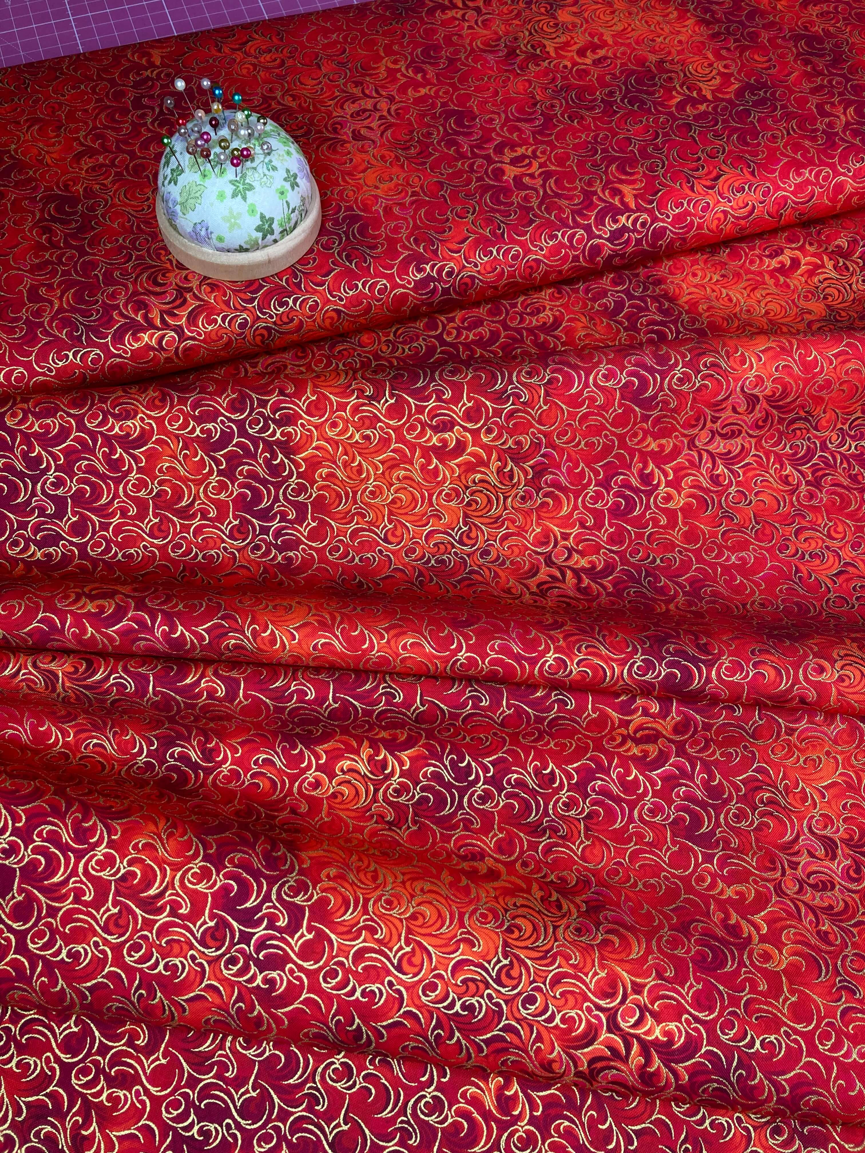 Red and metallic gold intricate swirling patterned cotton fabric
