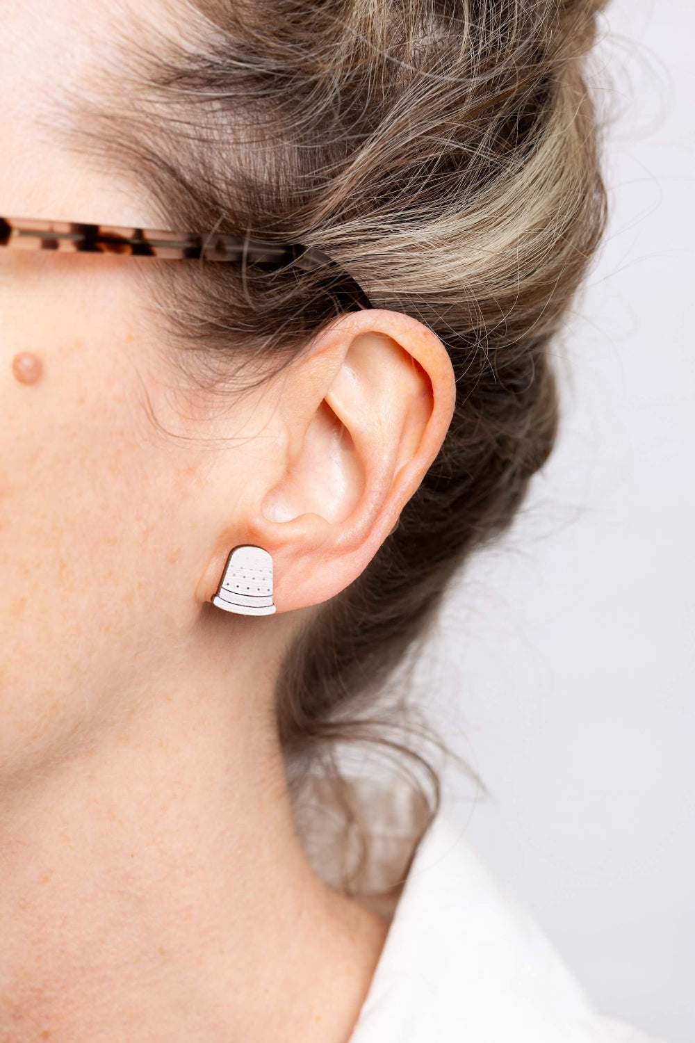 white thimble wooden earrings on ears
