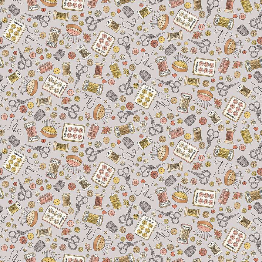 vintage themed sewing notions including pins, buttons, scissors and spools of thread on a light grey cotton fabric
