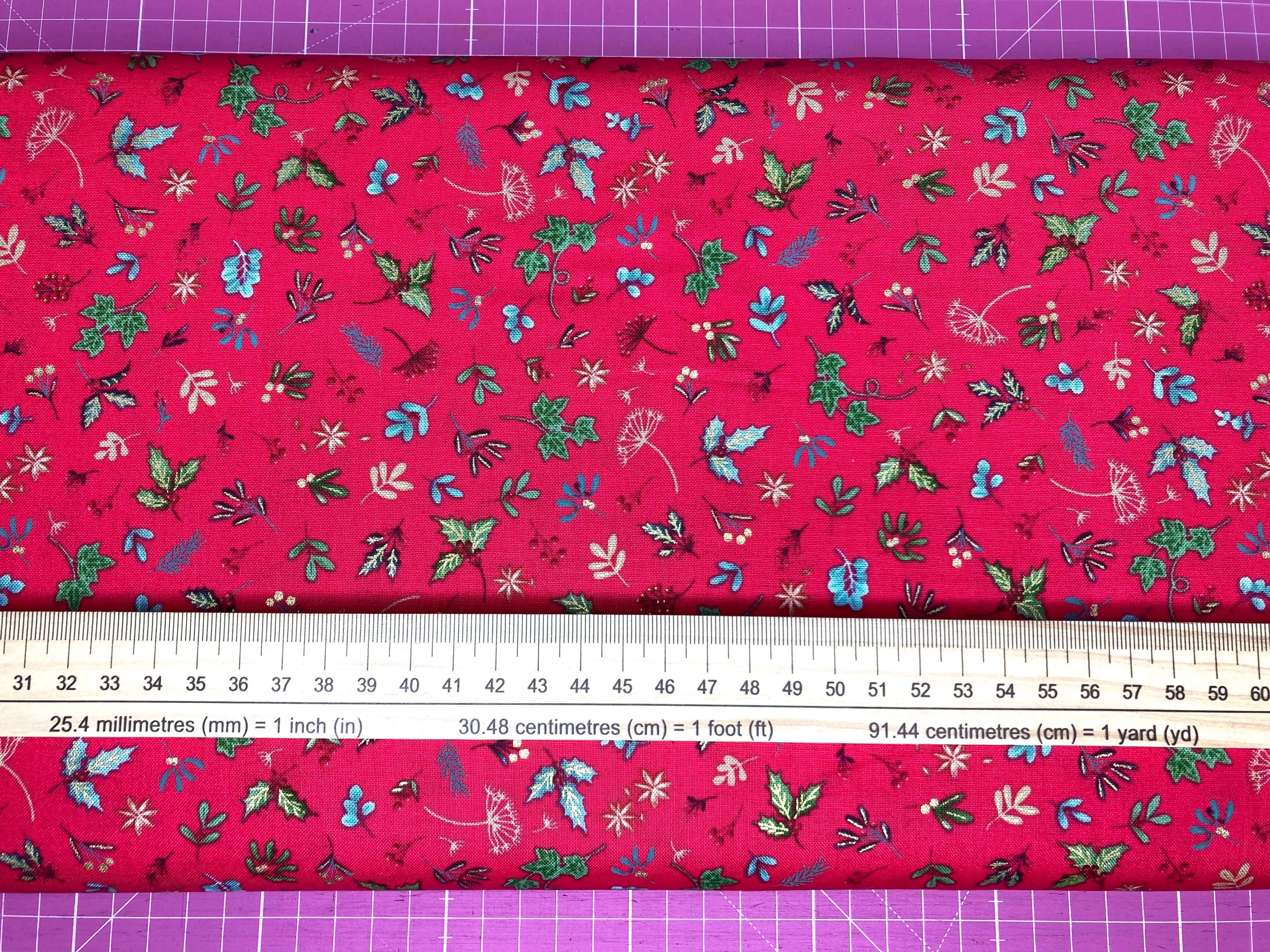 red green and metallic gold festive sprigs cotton fabric with ruler