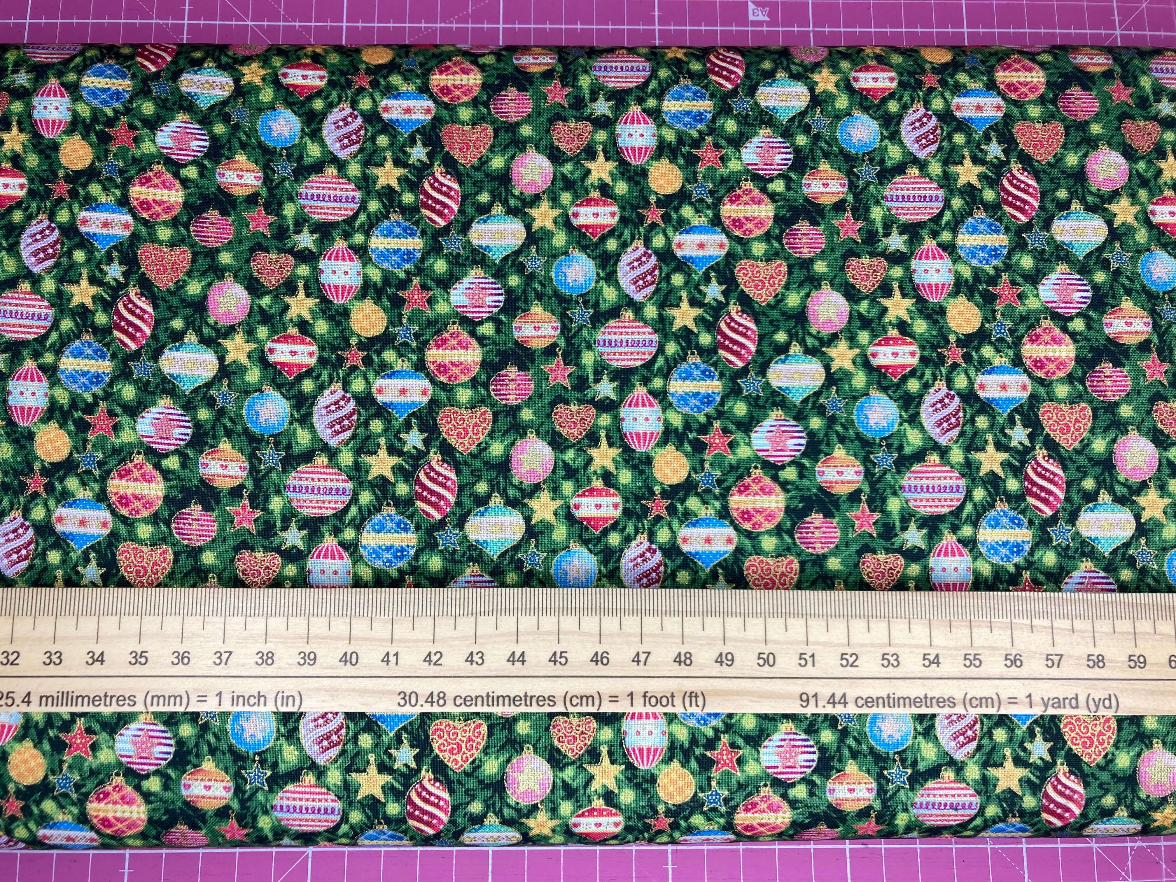 colourful vintage christmas baubles on a green background with metallic gold accents with ruler