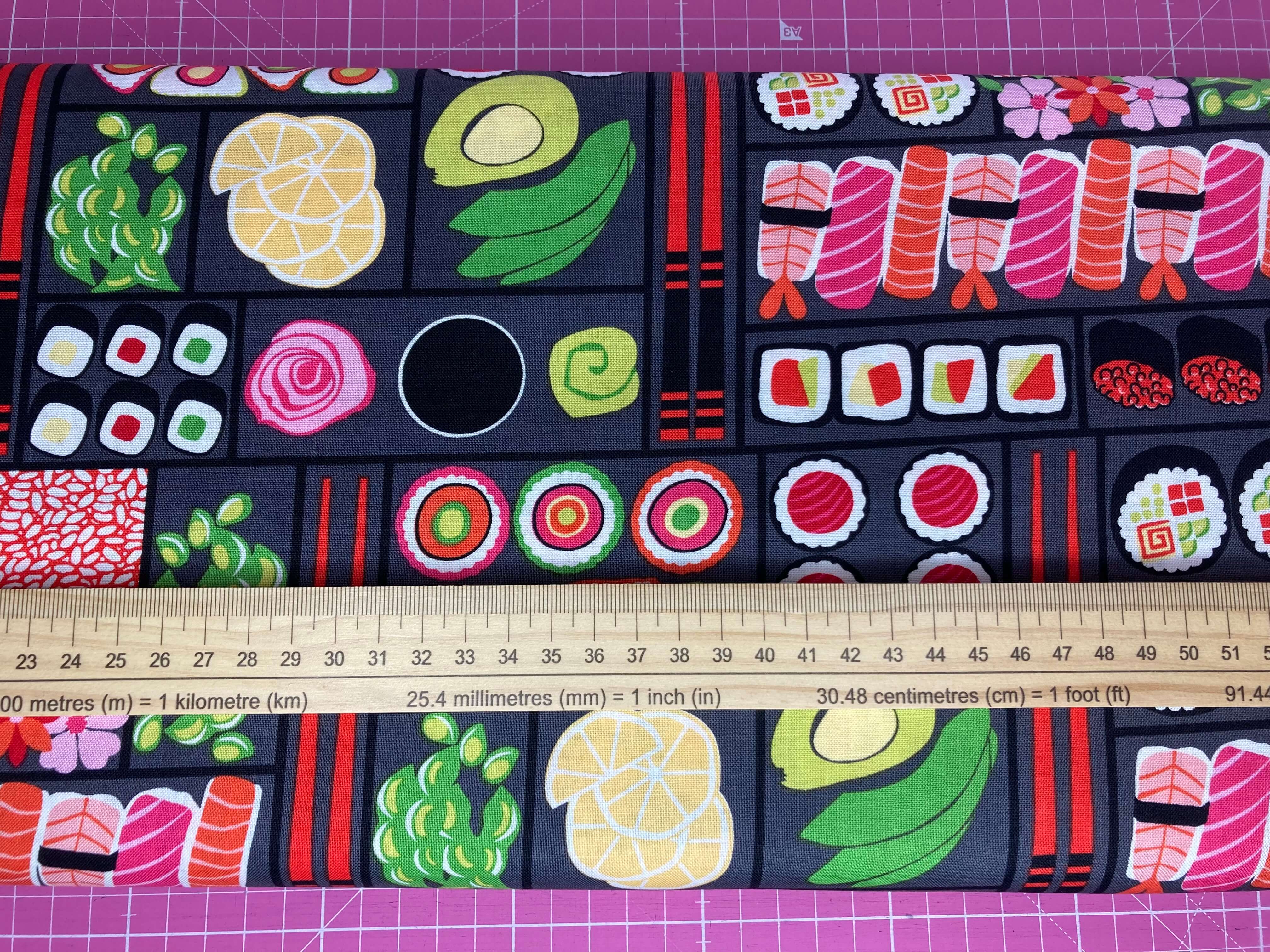 Colourful bento box sushi on cotton fabric with a ruler