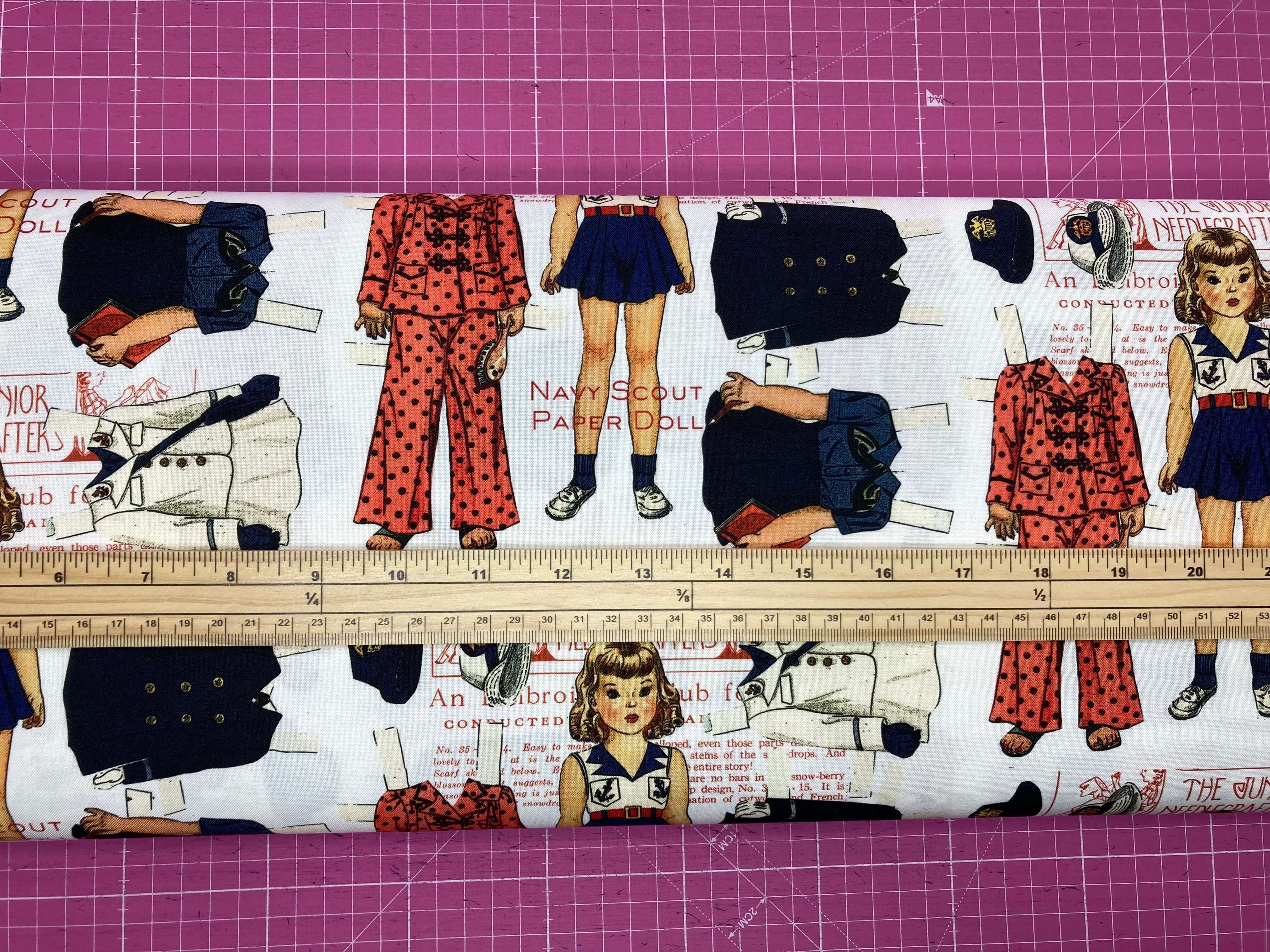 Navy Scout paper doll set with clothing pieces and a ruler for scale on a pink grid background.