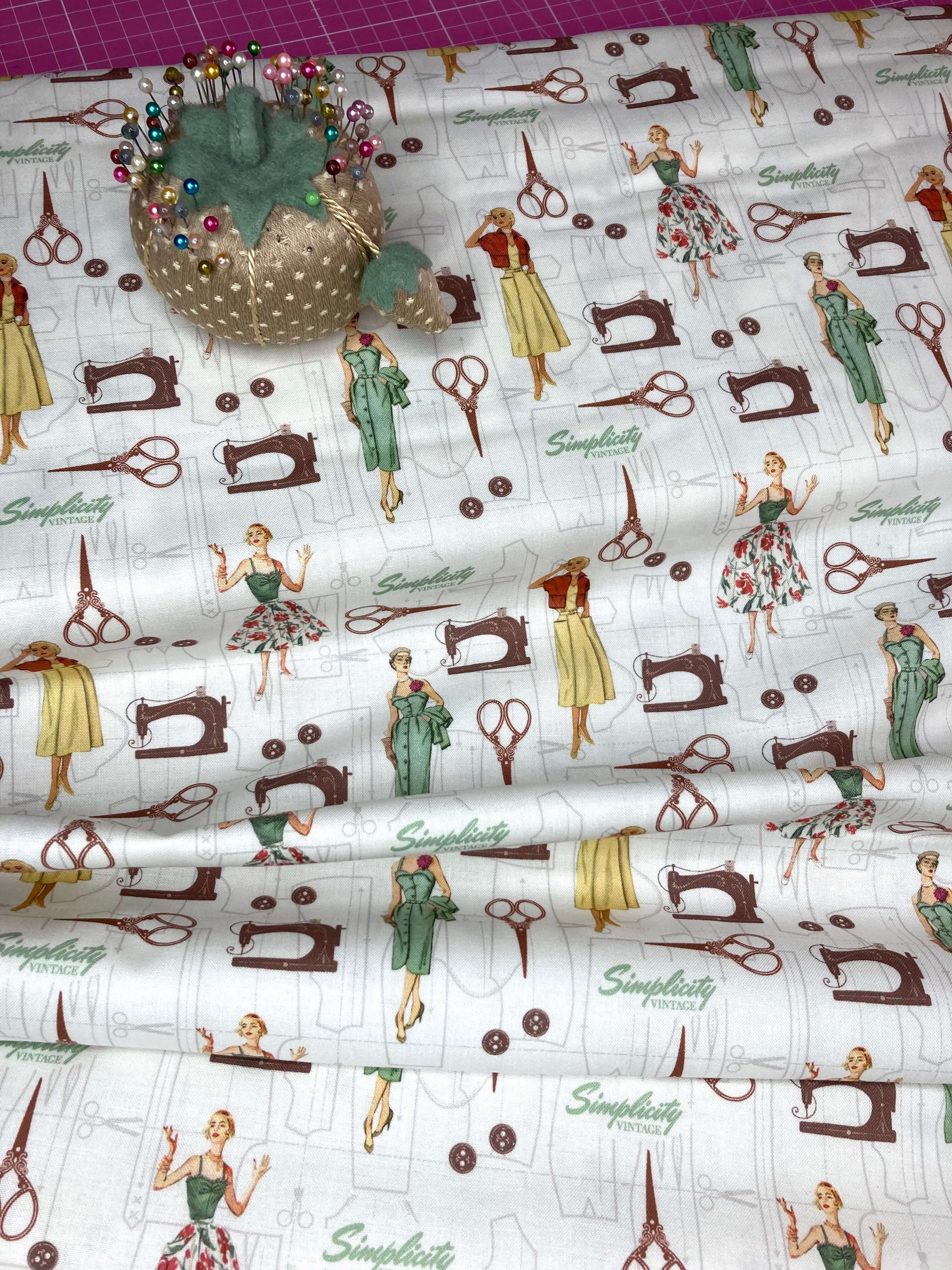 Fabric with vintage sewing-themed design featuring women, sewing machines, and scissors on a white background.