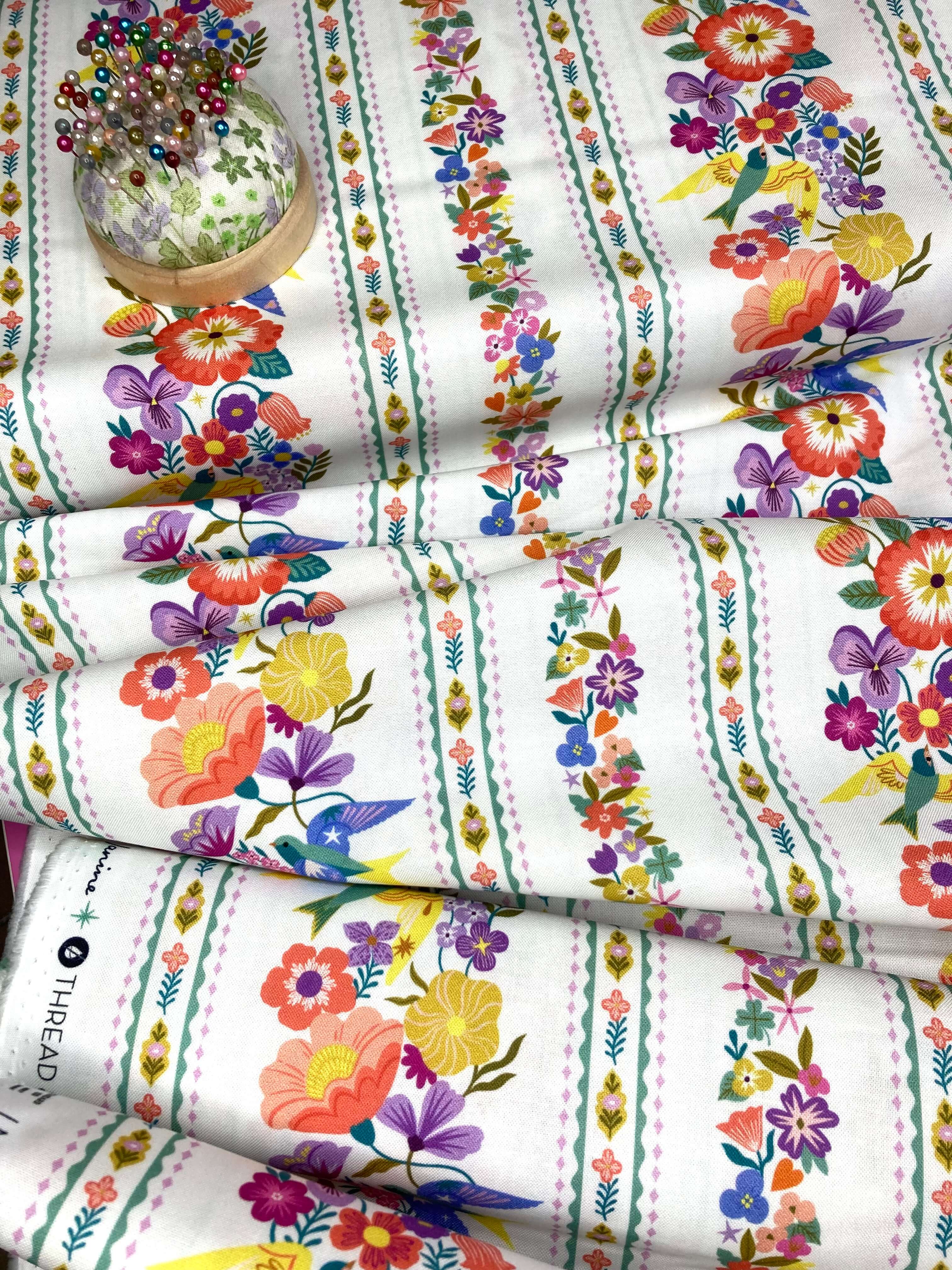 Decorative floral fabric with colorful flowers and birds on a white background