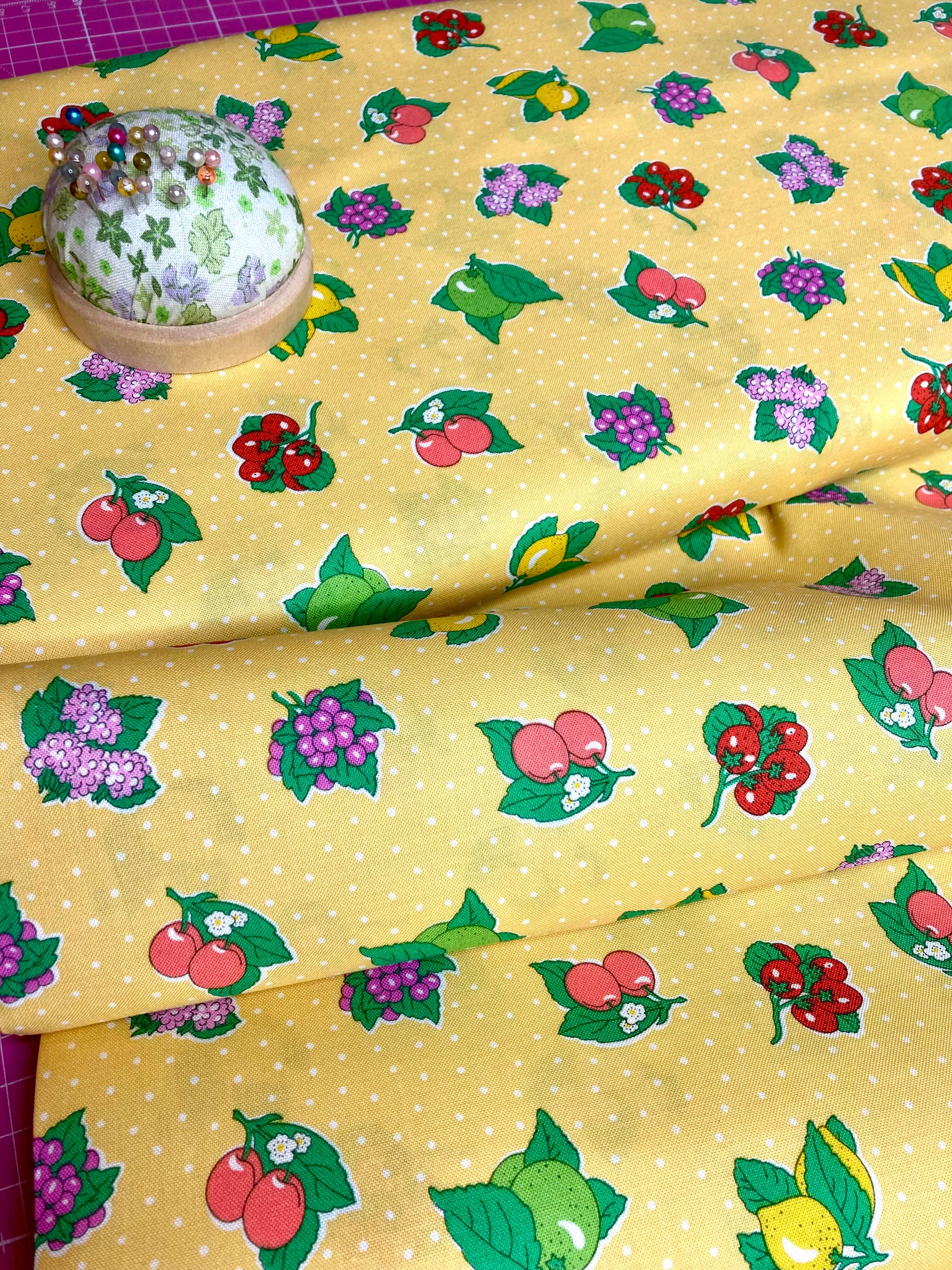 yellow cotton fabric with white polka dots and colourful fruit