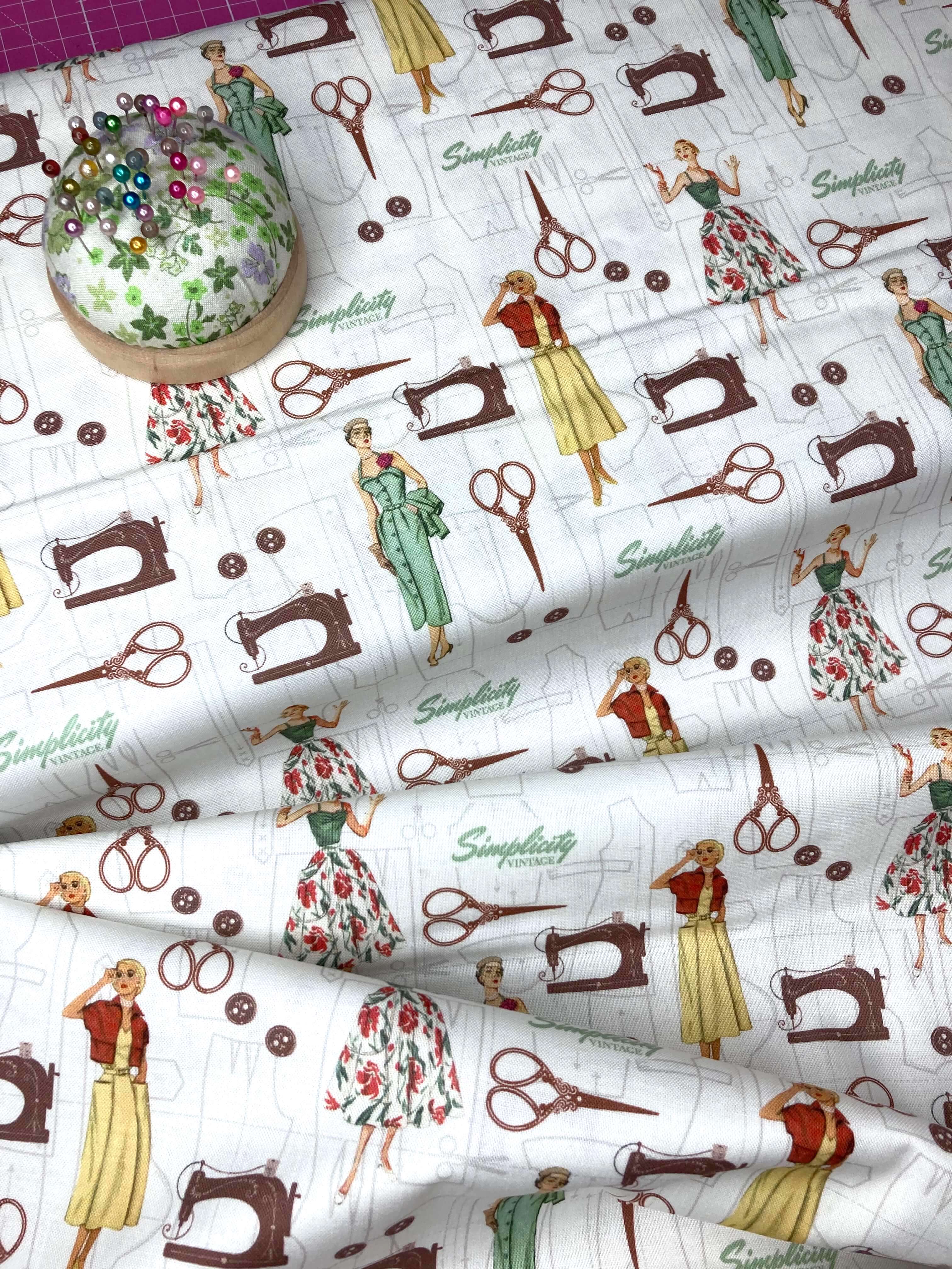 Fabric with vintage sewing-themed design featuring women, sewing machines, and scissors on a white background.