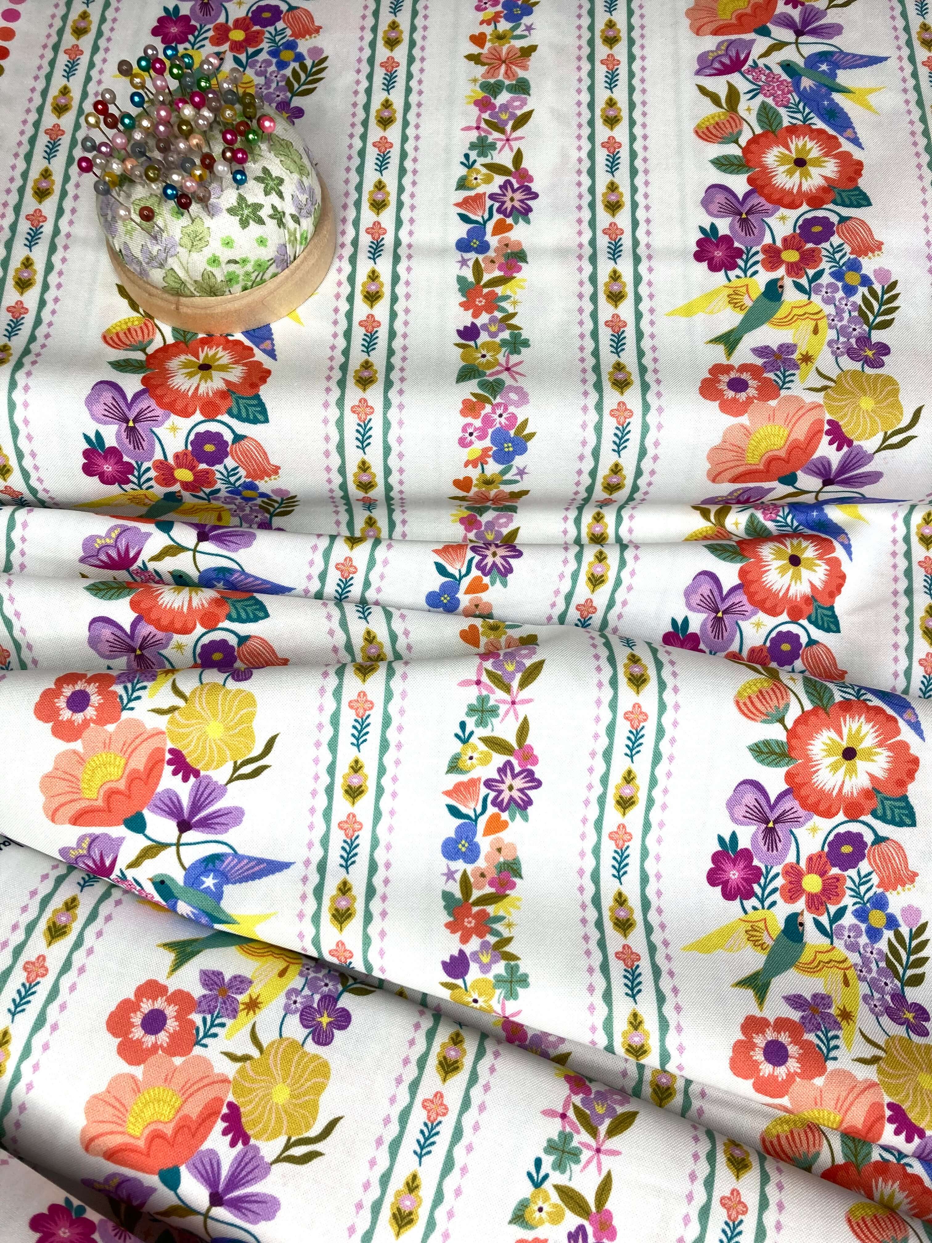 Decorative floral fabric with colorful flowers and birds on a white background